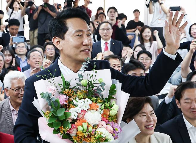 6·3 지방선거에서 당선된 오세훈 국민의힘 서울시장 후보가 4일 서울 종로구 선거사무소에서 꽃다발을 전달 받고 환호 하고 있다. 사진 뉴스1