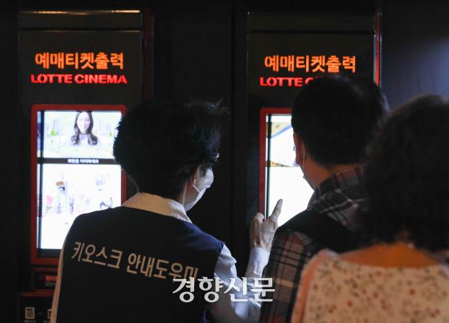 서울 청량리 롯데시네마에서 시니어 키오스크 안내 도우미가 손님의 키오스크 사용을 도와주고 있다. 우철훈 선임기자