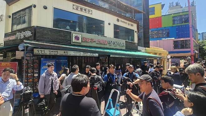 [서울=뉴시스] 젠슨 황 엔비디아 최고경영자(CEO)가 5일 오후 김포공항을 통해 입국했다. 황 CEO는 이날 저녁 서울 마포구 홍대입구역 인근 식당에서 최태원 SK그룹 회장, 구광모 LG그룹 회장 등과 저녁 식사를 함께할 예정이다. 사진은 황 CEO와 최 회장 등의 저녁 식사가 예정된 식당 앞이 시민과 취재진 등으로 붐비는 모습. 2026.06.05 photo@newsis.com *재판매 및 DB 금지