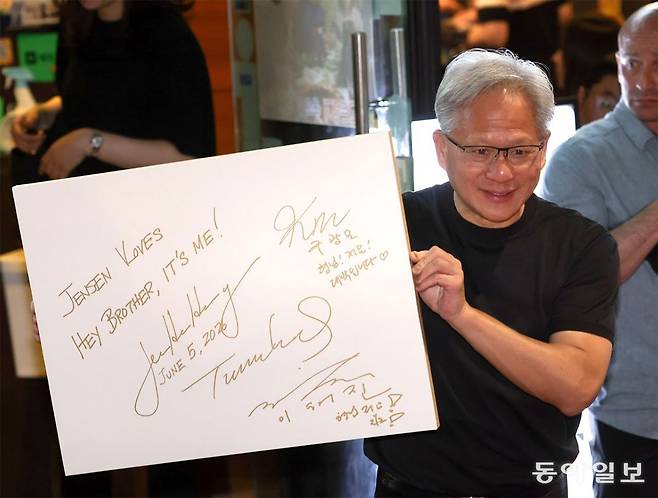 젠슨 황 엔비디아 최고경영자(CEO)가 5일 서울 마포구 홍대 인근의 한 고깃집에서 삼겹살 회동을 마친 뒤 ‘형님’이라고 적은 사인 판넬을 들어보이고 있다. 이한결 기자 always@donga.com