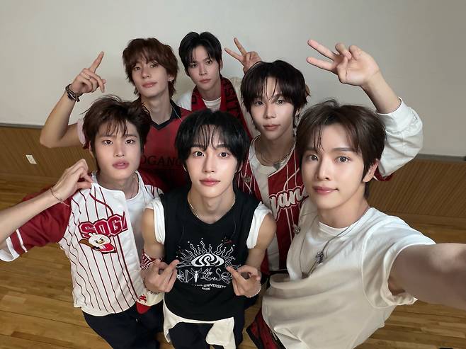 Riize members take a photo wearing Sogang University merch after performing at the university's spring festival on May 14. [SCREEN CAPTURE]