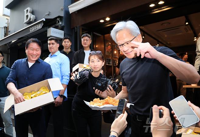 젠슨 황 엔비디아 최고경영자(CEO)와 최태원 SK그룹 회장이 7일 오후 서울 강남구 깐부치킨 삼성점에서 '치맥 회동' 중 시민 및 취재진에게 치킨을 나눠주고 있다. 2026.6.7 ⓒ 뉴스1 이호윤 기자
