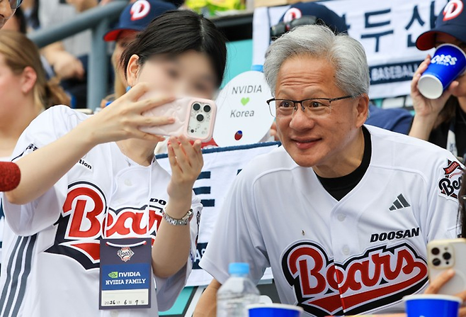 젠슨 황 엔비디아 최고경영자(CEO)가 7일 서울 잠실야구장에서 열린 2026 프로야구 KBO리그 키움 히어로즈와 두산 베어스의 경기를 관람하며 팬들과 기념사진을 촬영하고 있다. [연합뉴스]