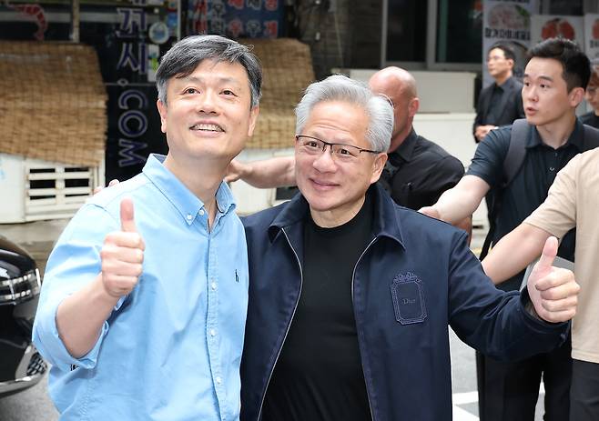 젠슨 황 엔비디아 최고경영자(CEO)와 장병규(왼쪽) 크래프톤 의장이 7일 서울 강남구에 있는 한 PC방 앞에서 만나 엄지척하고 있다. [연합뉴스]