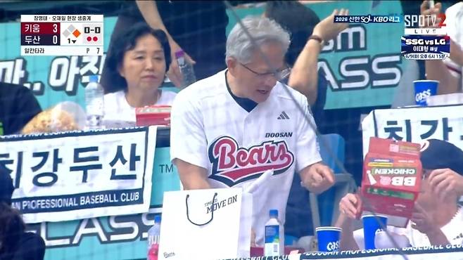 젠슨 황 엔비디아  CEO가 7일 서울 잠실야구장에서 시구를 마친 뒤 단체 괌람석에서 BBQ치킨을 먹고 있다. 중계화면 캡처