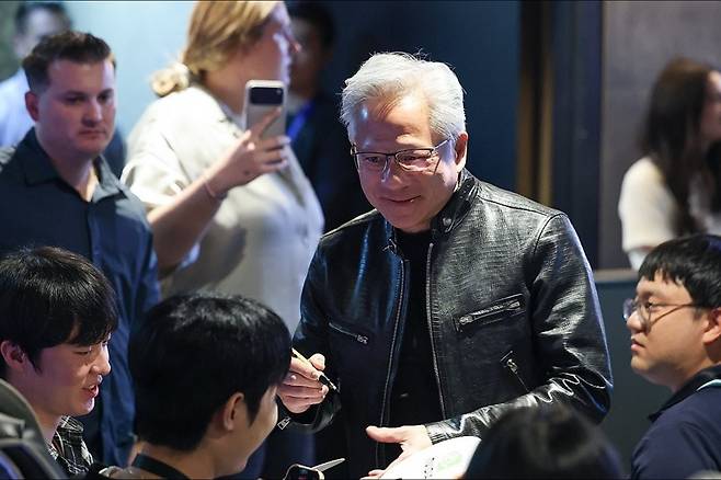 젠슨 황 엔비디아 최고경영자(CEO)가 지난 7일 서울 서초구 포털 PC방에서 이용객들에게 사인해주고 있다. 연합뉴스