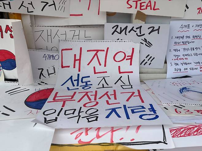 8일 오전 서울 송파구 올림픽공원 개표소 시위 현장에 부정선거를 주장하는 팻말이 붙어 있다. 김예정 기자