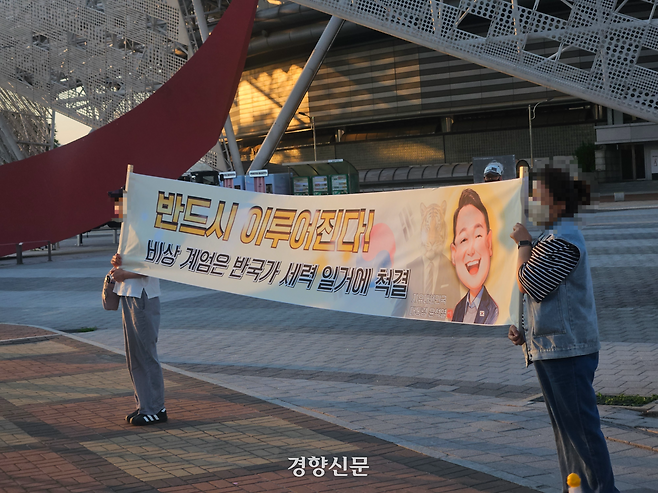 8일 오후 서울 송파구 올림픽공원 핸드볼경기장에서 시위 참여자들이 윤석열 전 대통령 관련 플랜카드를 들고 있다. 박민규 기자
