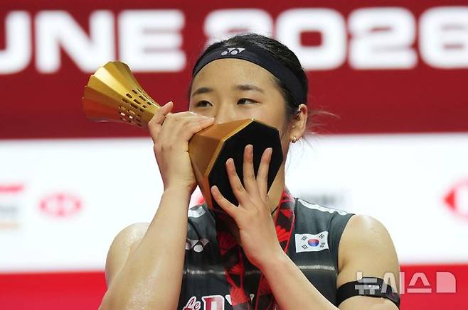 [자카르타=AP/뉴시스] 안세영(1위)이 7일(현지 시간) 인도네시아 자카르타에서 열린 '2026 세계배드민턴연맹(BWF) 월드투어 슈퍼1000 인도네시아 오픈 여자 단식 정상에 올라 트로피를 들고 입 맞추고 있다. 안세영은 결승에서 야마구치 아카네(3위·일본)를 2-0(23-21 21-12)으로 완파하고 우승하며 대회 2연패를 달성했다. 2026.06.08.