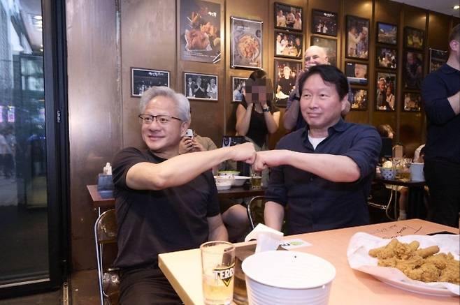 젠슨 황(왼쪽) 엔비디아 최고경영자(CEO)와 최태원 SK그룹 회장이 7일 서울 강남구 삼성동 깐부치킨에서 치맥(치킨+맥주)으로 2차 깐부회동을 하던 도중 주먹 인사를 하고 있다. 이 장소는 지난해 10월 말 황 CEO가 이재용 삼성전자 회장, 정의선 현대차그룹 회장과 첫 ‘깐부 회동’을 한 곳이다. SK수펙스추구협의회 제공