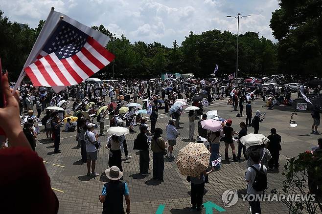 6ㆍ3 지방선거 개표소 봉쇄 시위 계속 (서울=연합뉴스) 윤동진 기자 = 6·3 지방선거 투표용지 부족 사태를 규탄하며 재선거를 요구하는 '잠실 개표소 봉쇄 시위'가 계속되고 있는 8일 서울 송파구 올림픽공원 핸드볼경기장 출입구 앞에서 참가자들이 구호를 외치고 있다. 2026.6.8 mon@yna.co.kr