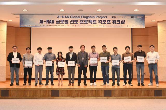지난 4일 열린 ‘AI-RAN 글로벌 선도 프로젝트 킥오프 워크숍’에서 에트리와 국내 이동통신 3사 및 참여기관들이 국가지정 AI-RAN 전문연구소 협력기관 현판을 수여받고 기념촬영하는 모습 [사진=ETRI]
