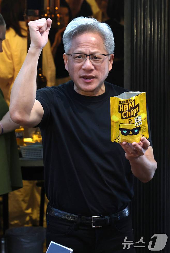 젠슨 황 엔비디아 최고경영자(CEO)가 5일 서울 마포구 홍익대학교 인근 고깃집에서 최태원 SK회장, 구광모 LG회장, 이해진 네이버 의장과 삼겹살, 소맥(소주·맥주) 회동 중 잠시 나와 HBM칩스를 나눠주며 주먹을 쥐어보이고 있다. 2026.6.5 ⓒ 뉴스1 이광호 기자