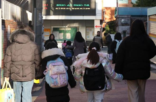 4일 오전 서울 한 초등학교 부근에서 학부모가 자녀들과 교문으로 향하고 있다. 이날 새벽 교육부는 '모든 업무와 학사 일정은 정상운영한다'고 밝혔다. 연합뉴스