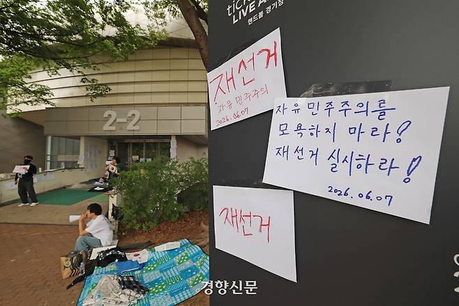 6·3 지방선거에서 일어난 투표용지 부족 사태를 비판하며 재선거를 요구하는 시민들이 지난 7일 서울 송파구 올림픽공원 핸드볼경기장 개표소 앞에 모여 구호를 외치고 있다. 정효진 기자
