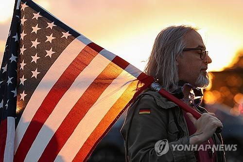 미국 국기 들고 있는 시민 [로이터=연합뉴스 제공]