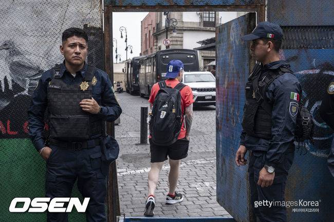 MEXICO CITY, MEXICO - MAY 18: Mexico City police guard the main square as a person wearing clothing alluding to the 2026 World Cup enters on May 18, 2026 in Mexico City, Mexico. (Photo by Cristopher Rogel Blanquet/Getty Images)Just days before the opening of the 2026 World Cup, the Mexico City government is maintaining security barriers due to protests by teachers from the National Coordinator of Education Workers (CNTE).