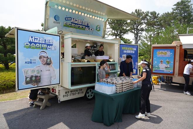 10일 ‘메르세데스-벤츠 제40회 한국여자오픈골프선수권대회’ 공식연습일이 진행되는 동안 삼천리 스포츠단 서교림 프로와 ‘지도표 성경김’ 성경식품이 서교림 프로의 생애 첫 우승에 감사한 마음을 전하기 위해 경기장을 찾은 모든 선수와 관계자에게 충무김밥과 지도표 성경김 김부각 및 어포튀각 등 다채로운 먹거리를 제공하는 푸드트럭을 마련했다. 사진 | 삼천리