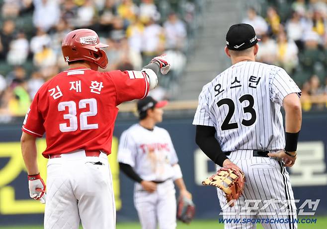 맞는 순간 사라진 타구가 폴대 위를 크게 넘어가자 김재환이 위치를 가리키며 비디오 판독 기다리고 있다.