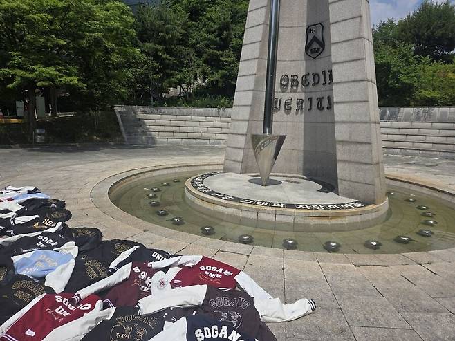 10일 오후 서울 마포구 서강대학교 정문 알바트로스탑 앞에 중앙선거관리위원회의 투표용지 부족 사태로 인한 ‘참정권 침해’에 항의의 표시로 서강대 학생들이 학과 점퍼를 바닥에 내려 놓은 모습. 박찬희 기자