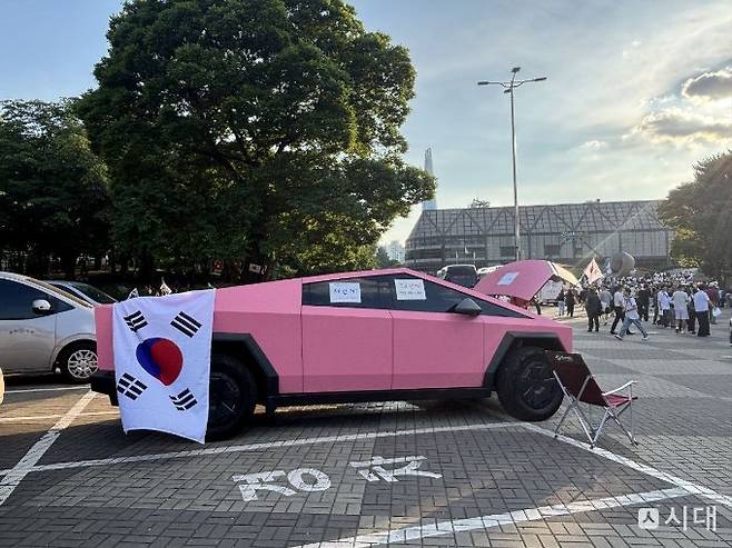 8일 '재선거 요구' 시위가 열린 서울 송파구 올림픽공원 핸드볼경기장에는 핑크색 테슬라 사이버 트럭이 등장해 시위대의 시선을 끌었다. 차량에는 시위대 누구가 가져갈 수 있도록 김밥과 음료수가 비치돼 있었다. /사진=최혜승 기자