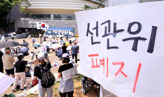 10일 서울 송파구 올림픽공원 핸드볼경기장 개표소 앞에 시민들이 모여 구호를 외치고 있다. 뉴스1