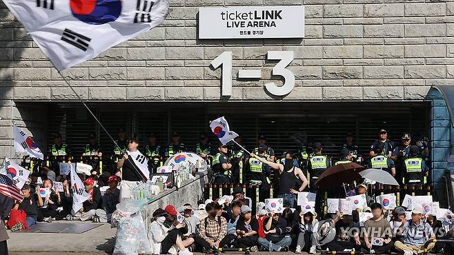 계속되는 개표소 봉쇄 시위 (서울=연합뉴스) 이진욱 기자 = 투표지 부족 사태'를 규탄하며 재선거를 요구하는 '잠실 개표소 봉쇄 시위'가 1박 2
일째 계속되는 가운데 6일 개표소인 서울 송파구 올림픽공원 핸드볼경기장 앞에서 부정선거를 주장하는 시민들과 보수 성향 유튜버 등이 구호를 외치고 있다. 2026.6.6 cityboy@yna.co.kr