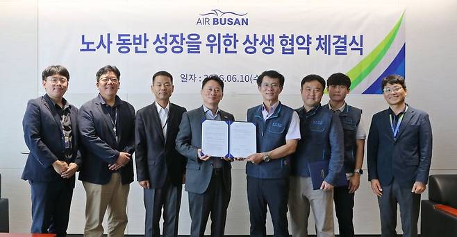 정병섭 에어부산 대표이사(왼쪽 네 번째)와 남이훈 에어부산 조종사노동조합 위원장(왼쪽 다섯번째)을 비롯한 노사 관계자들이 지난 10일 에어부산 사옥에서 상생 협약을 체결한 뒤 기념촬영을 하고 있다. 에어부산 제공