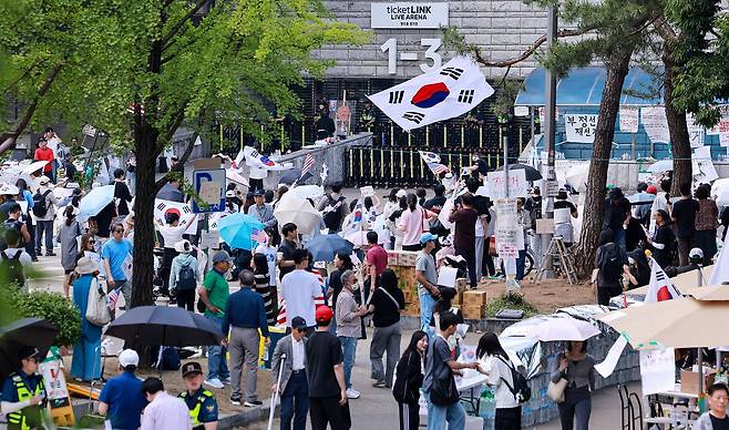 제9회 전국동시지방선거 투표용지 부족 사태를 규탄하며 재선거를 요구하는 집회가 계속되는 10일 서울 송파구 올림픽공원 핸드볼경기장 개표소 앞에 시민들이 모여 재선거를 요구하는 구호를 외치고 있다. 뉴스1
