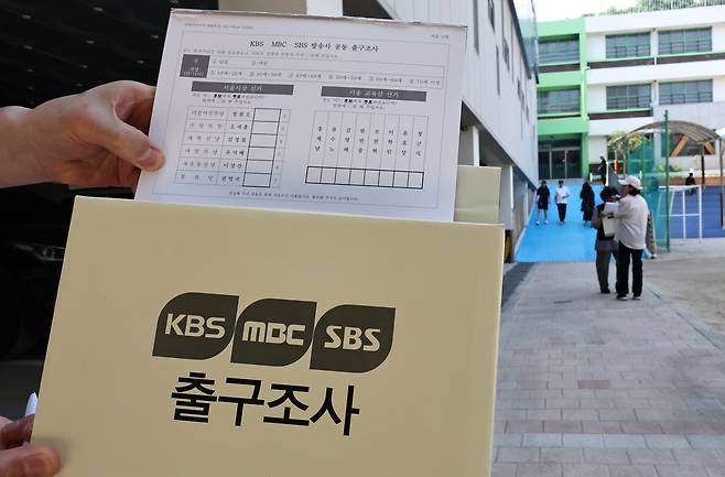 6·3지방선거일인 지난 3일 서울 동작구 본동초등학교에 마련된 노량진1동 제6투표소 앞에서 출구 조사원이 출구조사를 하고 있다. 연합뉴스