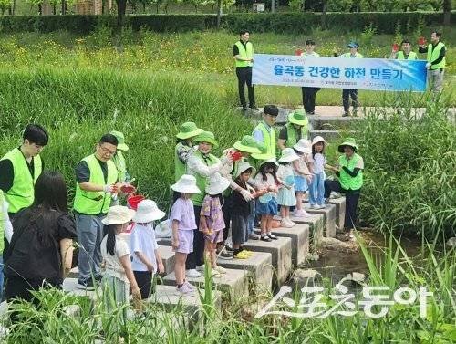 김천시 율곡동이 지역 어린이들과 함께 토종어류를 방류하고 있다. 사진제공 ㅣ 김천시