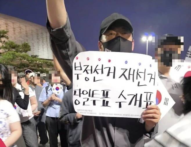 장동혁 국민의힘 대표가 9일 서울 송파 올림픽공원을 찾아 '부정선거 재선거' 등이 적힌 팻말을 들고 있다. 온라인 커뮤니티 캡처