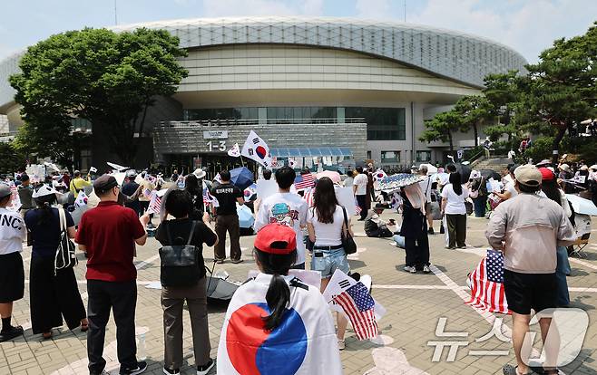 제9회 전국동시지방선거 투표용지 부족 사태를 규탄하는 개표소 봉쇄 시위가 계속된 12일 서울 송파구 올림픽공원 핸드볼경기장 앞에서 시민들이 태극기를 흔들며 재선거를 요구하고 있다. 2026.6.12 ⓒ 뉴스1 오대일 기자