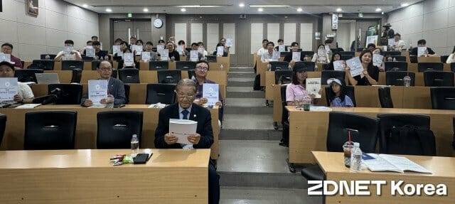 하계 공동 학술 대회 참석자들이 학술대회 책자를 들어 보이고 있다.