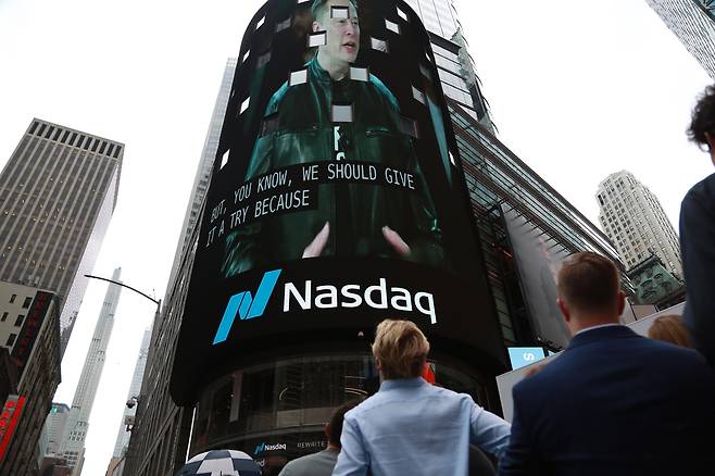 People watch the initial public offering ceremony of SpaceX outside the Nasdaq building in Times Square in New York City, Friday. (Xinhua-Yonhap)