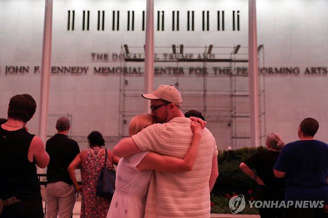 케네디센터 외벽의 철거작업 지켜보는 시민들 [AP=연합뉴스. 재판매 및 DB 금지]