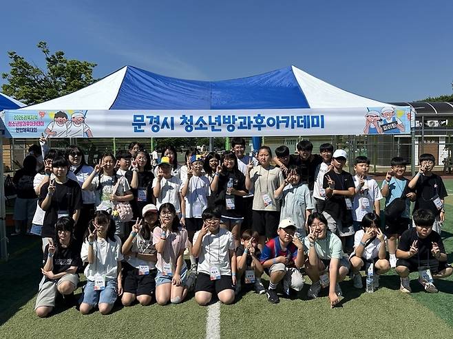 ▲ 문경시청소년방과후아카데미 참여 청소년과 봉사동아리 '나누리' 회원들이 13일 영강체육공원 축구장에서 열린 「2026년 경북지역 청소년방과후아카데미 연합체육대회」에 참가해 다양한 체육활동과 교류 프로그램을 즐기며 기념촬영을 하고 있다.