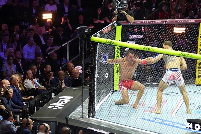 14일 워싱턴 백악관 남쪽 잔디밭에서 열린 UFC 프리덤 250 대회에서 도널드 트럼프 대통령(왼쪽 중앙)이 마우리시오 루피(오른쪽)와 마이클 챈들러의 라이트급 경기를 지켜보고 있다. /AP 연합뉴스