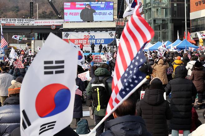 지난해 1월12일 오후 서울 용산구 한남동 대통령 관저 인근에서 열린 ‘윤석열 탄핵 무효’ 집회에서 참석자들이 태극기와 성조기를 흔들고 있다. 정용일 선임기자 yongil@hani.co.kr