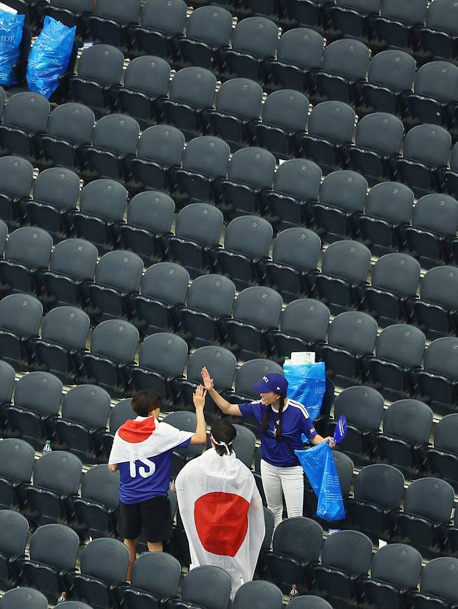 일본 축구팬들이 15일(한국시각) 미국 텍사스주 댈러스 스타디움에서 열린 2026 북중미월드컵 조별리그 F조 1차전 일본과 네덜란드의 경기가 끝난 뒤 관중석에서 쓰레기를 치우고 있다. 댈러스/로이터 연합뉴스