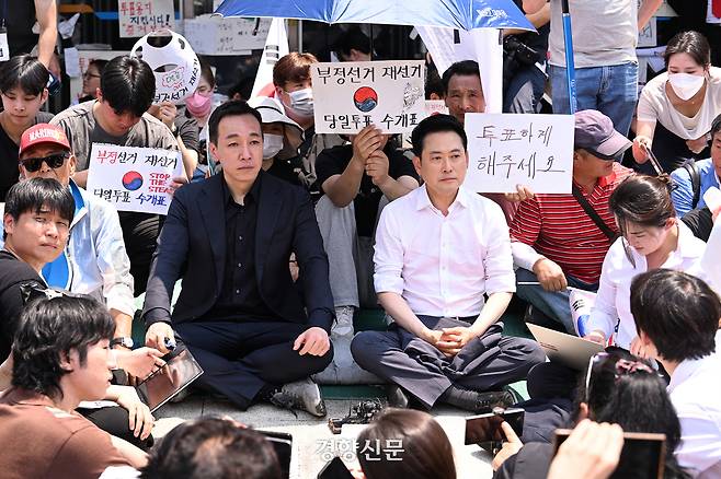 장동혁 국민의힘 대표와 김민수 국민의힘 최고위원이 16일 서울 송파구 올림픽공원 핸드볼경기장 2-1 출입구 앞에 앉아 있다. 한수빈 기자