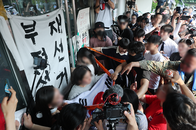 6·3 지방선거 투표용지 부족 사태로 시작된 올림픽공원 핸드볼경기장 봉쇄 시위가 이어지고 있다. 사진은 16일 시위에 참여한 시민이 대한체육회 관계자들의 핸드볼경기장 진입을 막고 있는 모습. [뉴스1]