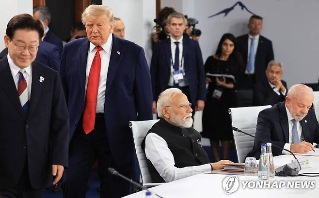 트럼프 미국 대통령과 함께 G7 회의 입장하는 이재명 대통령 [AFP=연합뉴스. 재판매 및 DB 금지]