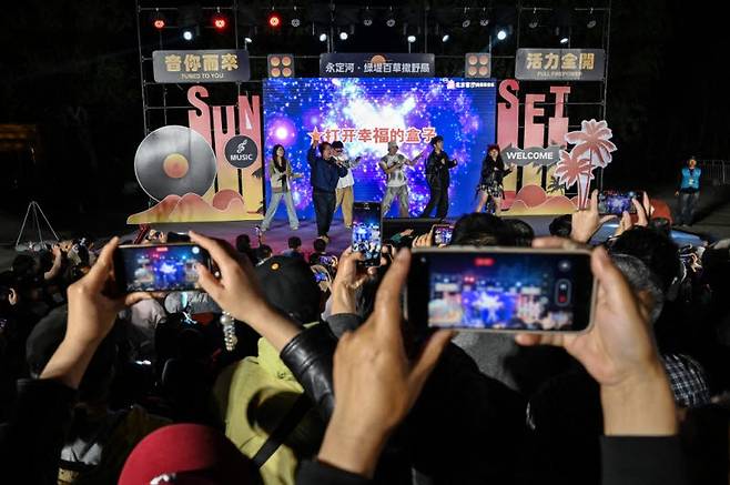 지난달 4일 중국 베이징의 한 공연에서 메이데이의 무료 공연이 열리고 있다. 이곳은 공원에서 열린 공연이라 관객들이 서서 관람이 가능했다. (사진=AFP)