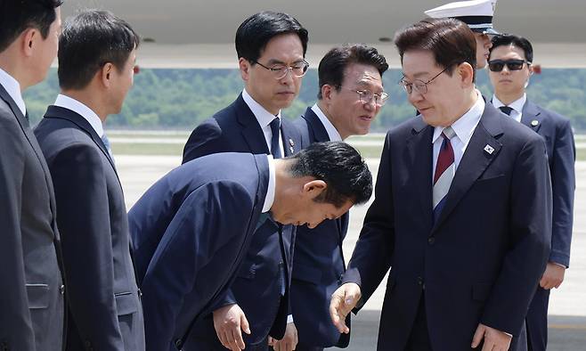 18일 유럽 순방을 마치고 귀국한 이재명 대통령이 마중 나온 더불어민주당 정청래 대표(왼쪽 세번째)의 90도 인사를 받으며 악수를 청하고 있다. 이 대통령은 정 대표와 악수한 뒤 “수고했습니다”라는 짤막한 인사를 남겼다. 앞서 9일 이 대통령 출국 당시 환송 행사에는 김민석 국무총리(왼쪽 다섯번째) 등 정부 인사들만 참가했고 정 대표 등 민주당 지도부는 나타나지 않았다. 청와대사진기자단
