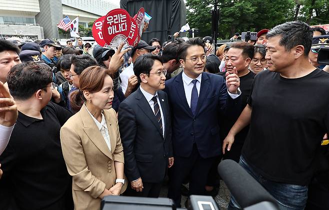 임오경, 전용기, 천준호 더불어민주당 의원이 17일 서울 송파구 올림픽공원 핸드볼경기장 앞에서 투표용지 부족 사태를 규탄하는 시민들에게 항의를 받으며 이동하고 있다. 뉴스1