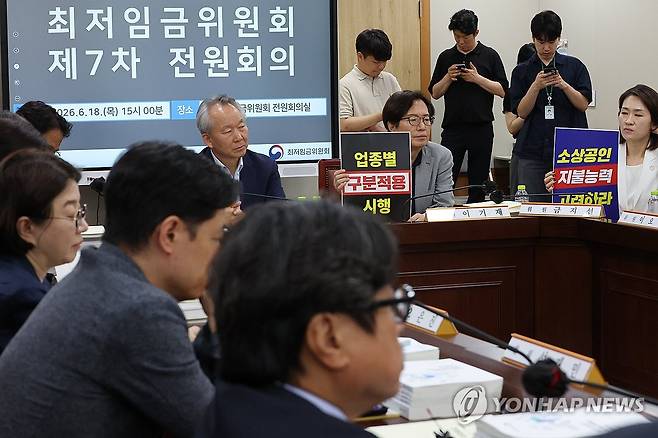 최저임금위, '업종별 구분 적용 지급' 노사 공방 (세종=연합뉴스) 김주성 기자 = 18일 정부세종청사 최저임금위원회에서 열린 제7차 전원회의에서 사용자 위원들이 최저임금의 업종별 구분적용을 요구하는 피켓을 들고 있다. 
    이날 회의에서는 숙박업과 식당 등에서는 최저임금을 낮게 책정하는 등 업종별로 달리 적용할지를 두고 노사 공방이 계속된다. 2026.6.18 utzza@yna.co.kr