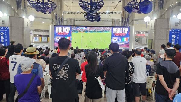 19일 남동구 인천시청역에 설치된 전광판을 통해 시민들이 축구 경기를 지켜보고 있다. [사진 = 김예빈 기자]