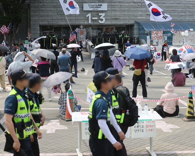 6·3 지방선거 투표용지 부족 사태로 촉발된 ‘개표소 봉쇄 시위’가 계속되고 있는 19일 서울 송파구 올림픽공원 핸드볼경기장 출입문 앞에서 참가자들이 구호를 외치고 있다. [연합뉴스]