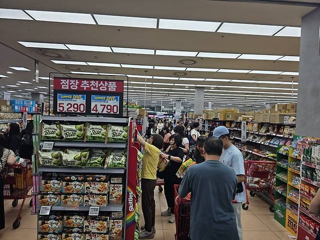 지난 18일 롯데마트 제타플렉스 서울역점에서 외국인 관광객들이 과자 제품을 고르고 있다. 서울역점은 공항철도와 KTX 이용객이 몰리는 입지 특성상 출국 전 한국 과자와 라면 등을 구매하려는 외국인 관광객 비중이 높은 매장으로 꼽힌다. 권용훈 기자